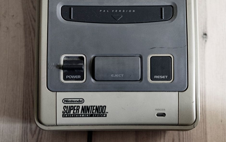 Old fashioned game console with buttons and words on plastic surface on wooden desk in flat